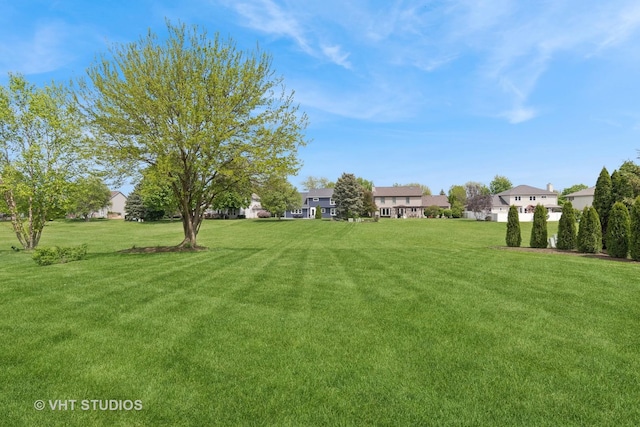 view of green lawn with a residential view