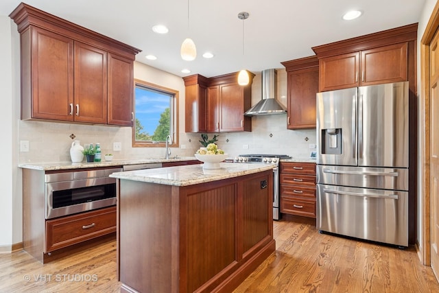 kitchen featuring stainless steel appliances, wall chimney exhaust hood, light wood-style floors, tasteful backsplash, and recessed lighting