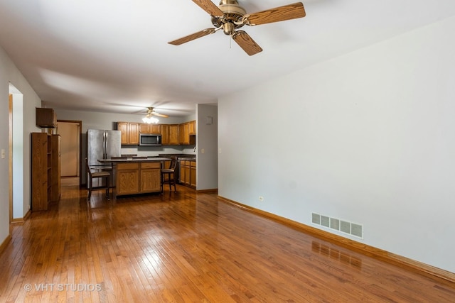 25W704 Jewell Rd, Wheaton, IL 60187 - kitchen with stainless steel appliances, dark countertops, a ceiling fan, dark wood-style flooring, and a center island