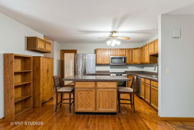 25W704 Jewell Rd, Wheaton, IL 60187 - kitchen featuring stainless steel appliances, a breakfast bar, dark countertops, and a center island