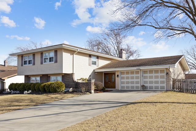1165 Mayfield Ln, Hoffman Estates, IL 60169 - tri-level home with fence, concrete driveway, an attached garage, brick siding, and a chimney
