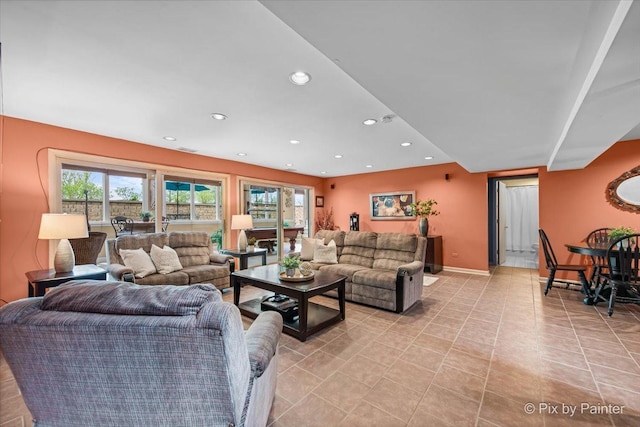living room featuring recessed lighting, baseboards, light tile patterned floors, and a wealth of natural light