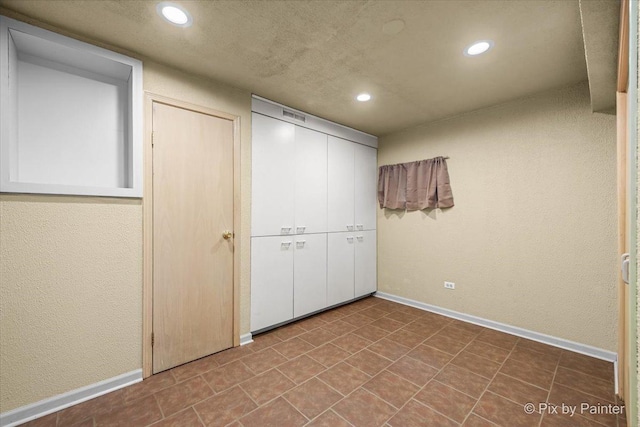 unfurnished bedroom with baseboards, a closet, and recessed lighting