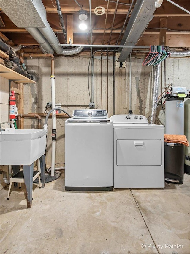clothes washing area featuring laundry area, a sink, and washer and clothes dryer