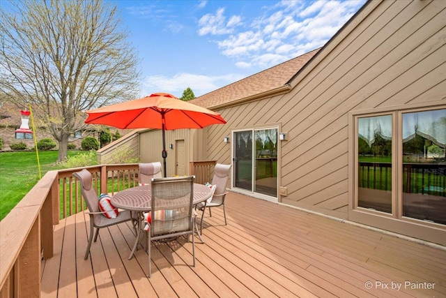 wooden terrace with a lawn and outdoor dining area