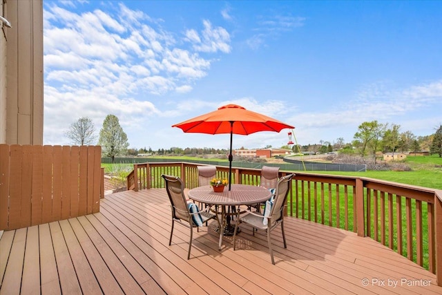 deck with a lawn, fence, and outdoor dining space