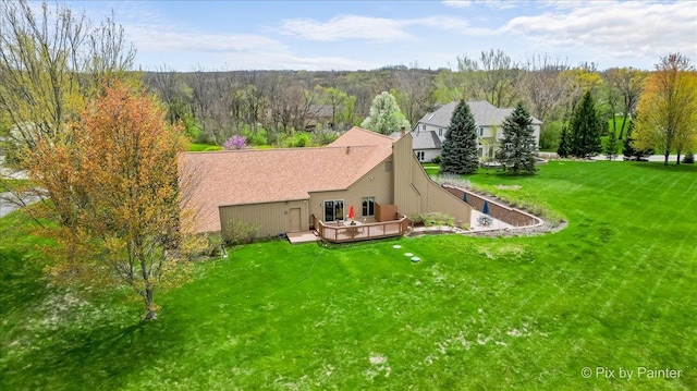 rear view of house with a wooded view, a yard, and a deck