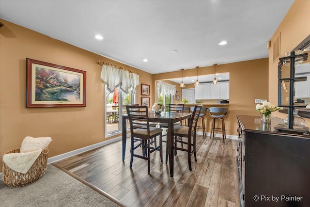 dining space with baseboards, recessed lighting, and wood finished floors