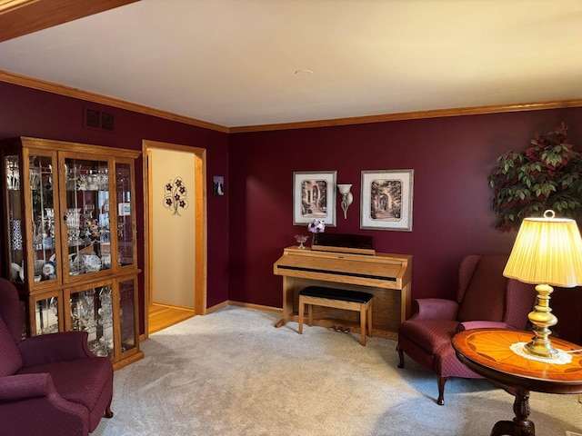 sitting room featuring visible vents, carpet floors, baseboards, and ornamental molding