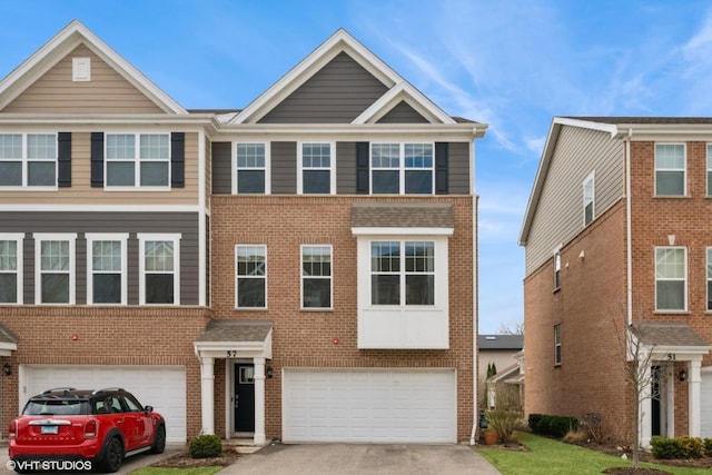view of property with brick siding, driveway, and a garage