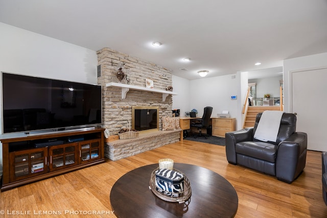living room featuring recessed lighting, a fireplace, and wood finished floors