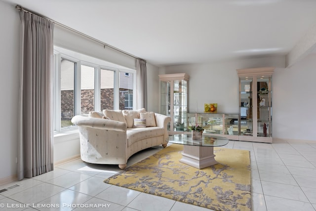 living room featuring light tile patterned floors, visible vents, and baseboards
