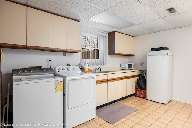 washroom with washer and clothes dryer, cabinet space, and a sink