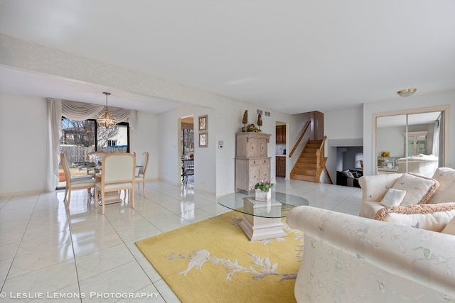 living area with baseboards, light tile patterned flooring, a chandelier, and stairs