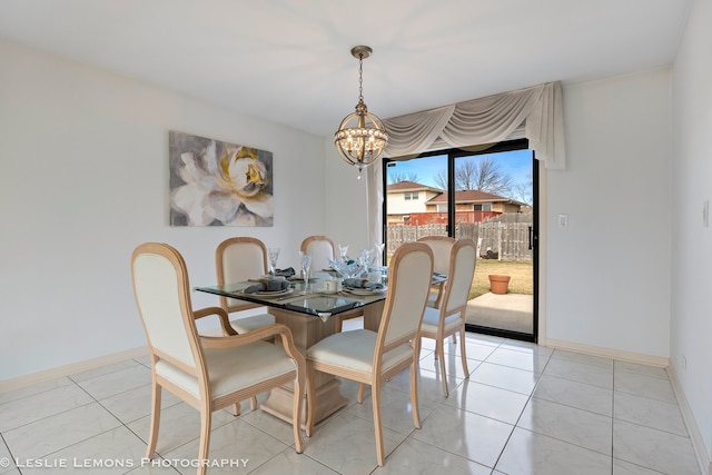 dining space with baseboards, a notable chandelier, and light tile patterned flooring