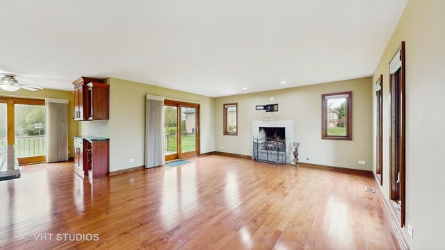 17N560 Hidden Hills Trl, Dundee, IL 60118 - unfurnished living room featuring a wealth of natural light, visible vents, a fireplace with flush hearth, and light wood-type flooring