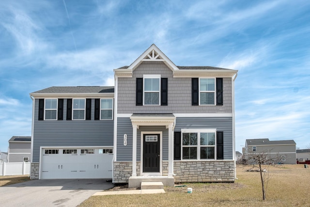 craftsman-style home featuring driveway, stone siding, and a garage