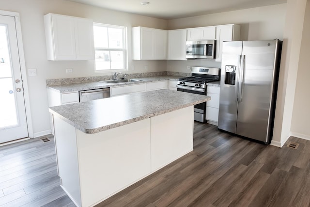 kitchen featuring a sink, stainless steel appliances, dark wood-style floors, and visible vents