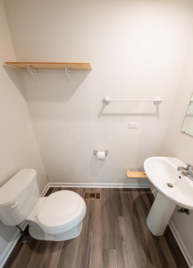 bathroom featuring baseboards, visible vents, toilet, and wood finished floors
