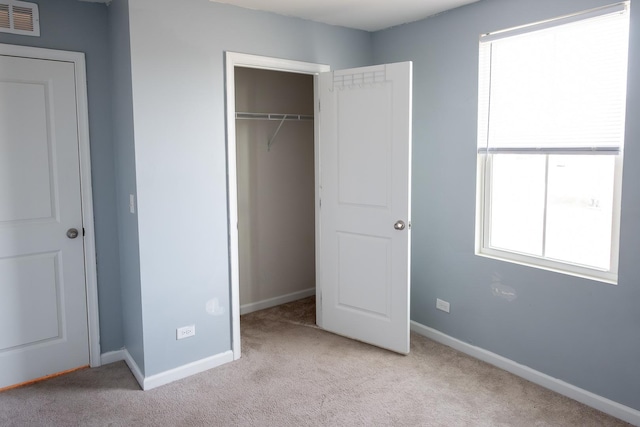 unfurnished bedroom with baseboards, visible vents, a closet, and carpet