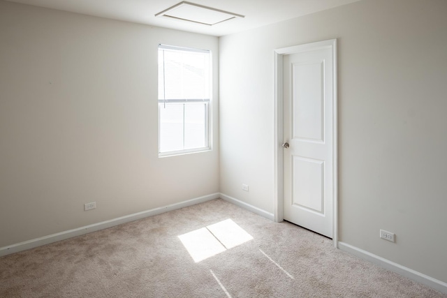 spare room featuring baseboards and light colored carpet