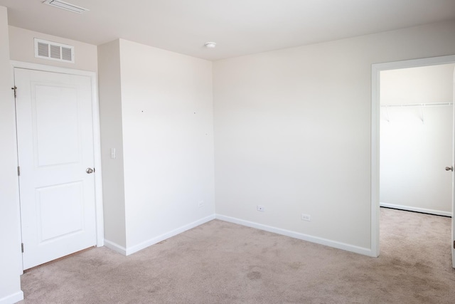 spare room featuring baseboards, visible vents, and carpet