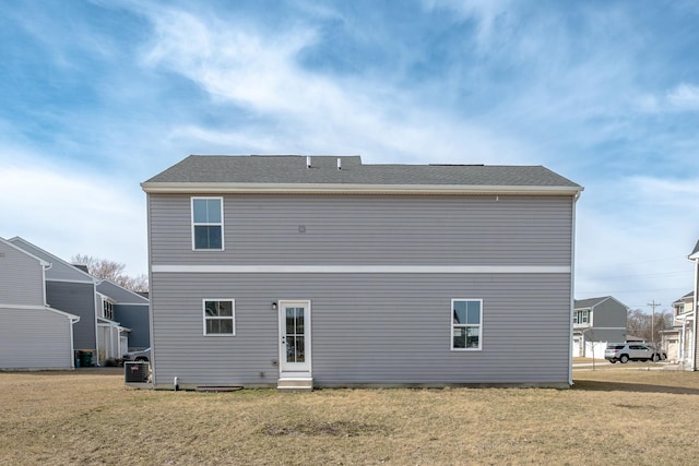 back of house featuring entry steps and a yard