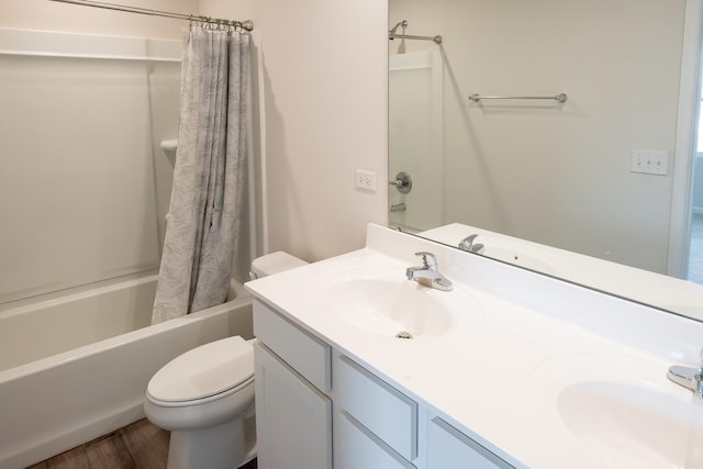 bathroom with shower / bath combo with shower curtain, a sink, toilet, and double vanity