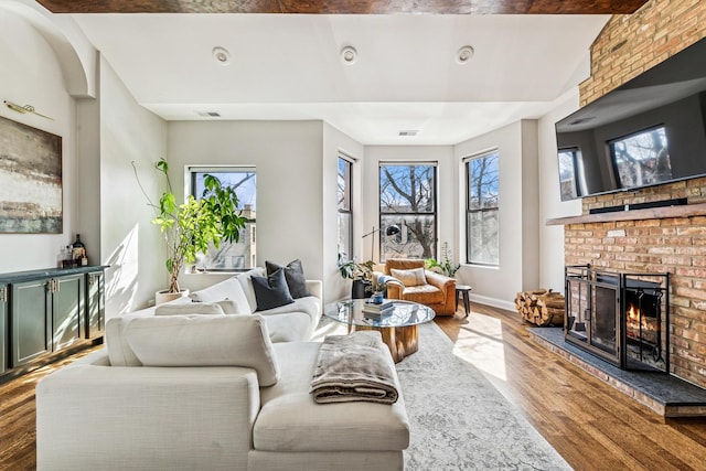 living room with a fireplace, plenty of natural light, and wood finished floors