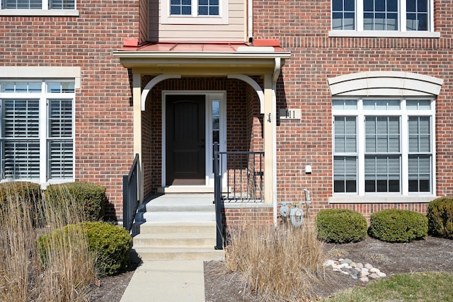 entrance to property featuring brick siding
