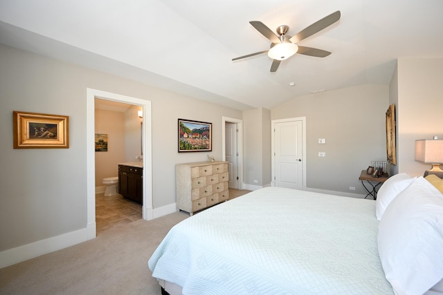 bedroom featuring ensuite bathroom, baseboards, light colored carpet, and lofted ceiling