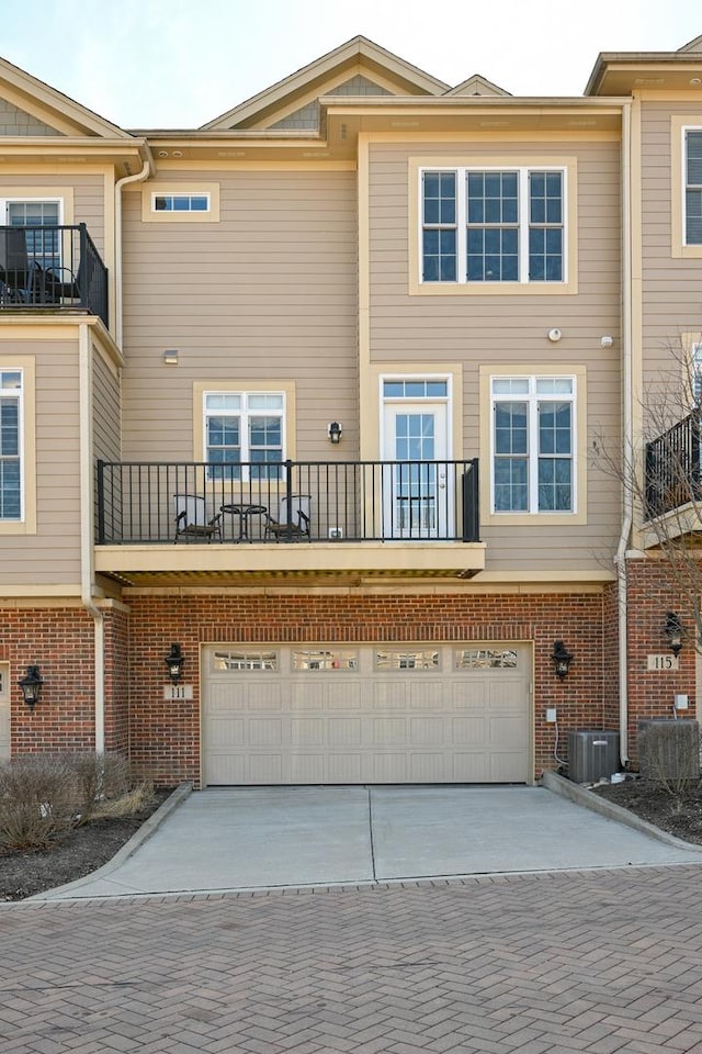 view of front of property featuring brick siding, driveway, and an attached garage