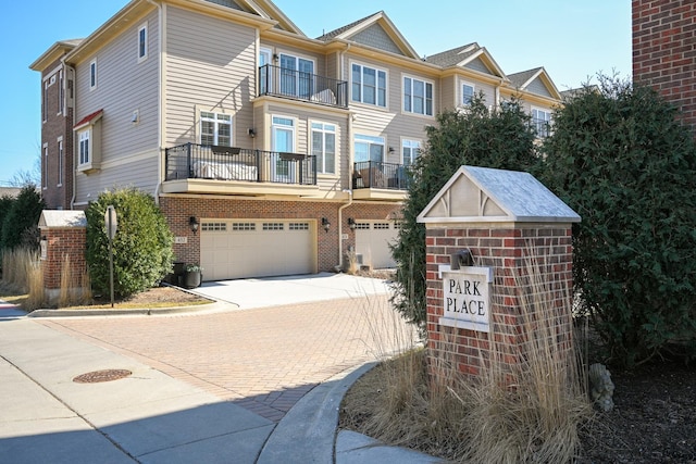 view of front of home with an attached garage, driveway, and brick siding