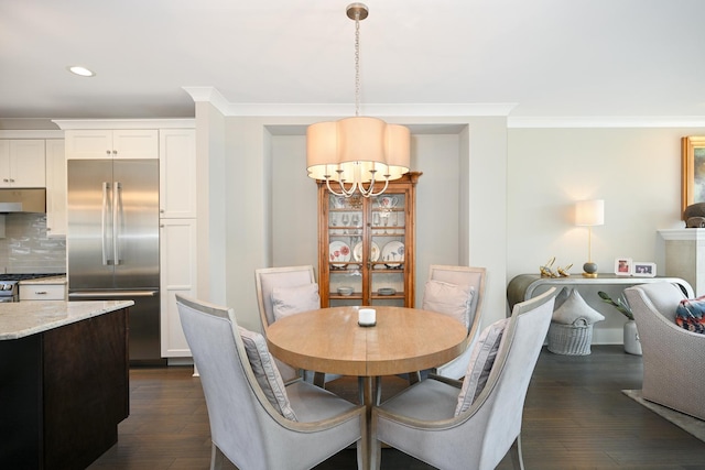 dining space with recessed lighting, dark wood-type flooring, a notable chandelier, and crown molding