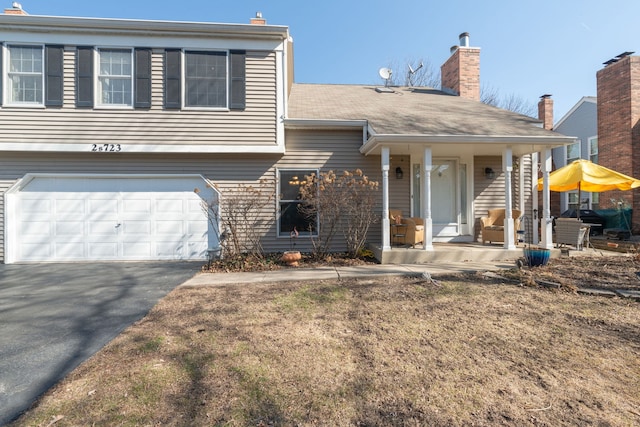2S723 Timber Dr, Warrenville, IL 60555 - view of front of home with aphalt driveway, covered porch, and an attached garage