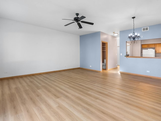unfurnished living room with visible vents, baseboards, light wood-style flooring, and ceiling fan with notable chandelier