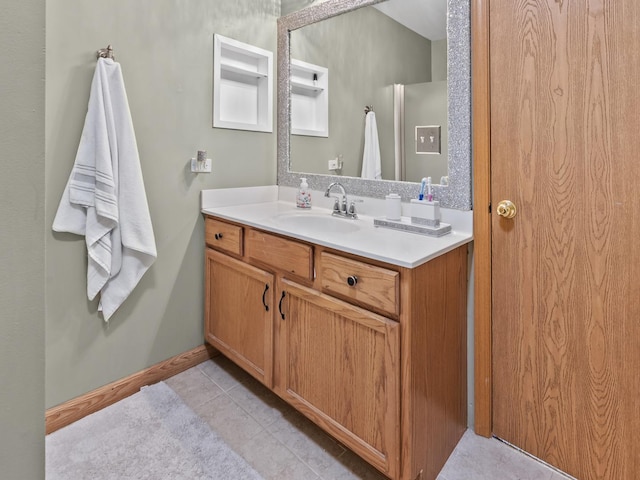 bathroom with vanity, tile patterned flooring, and baseboards
