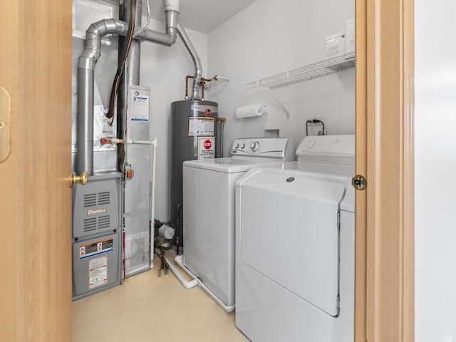 washroom featuring washer and clothes dryer, water heater, and laundry area