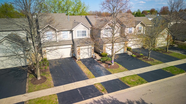 view of front facade with a residential view, driveway, and an attached garage