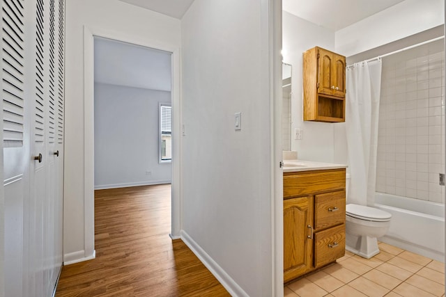 2275 Country Club Dr Unit 24, Woodridge, IL 60517 - bathroom with vanity, toilet, shower / bath combination with curtain, wood finished floors, and baseboards