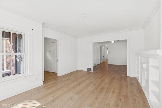 empty room featuring light wood-style flooring, baseboards, and ornamental molding