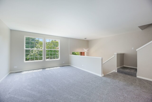 carpeted spare room with baseboards