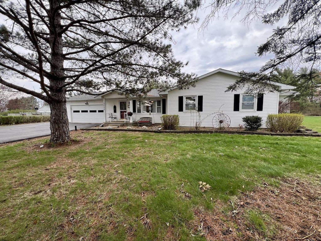 single story home with a garage, driveway, and a front lawn