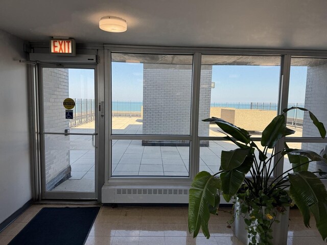 interior space featuring tile patterned floors, a water view, and radiator heating unit