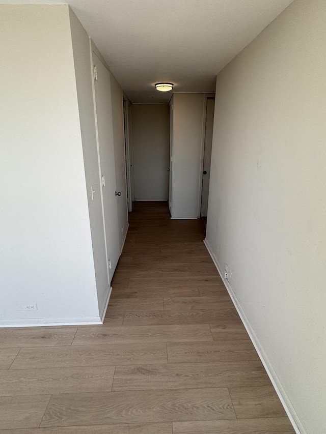 hallway with baseboards and light wood-style flooring
