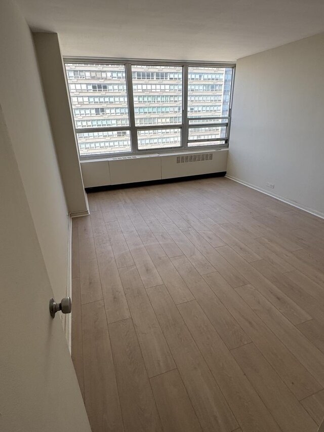 spare room with wood finished floors and a wealth of natural light