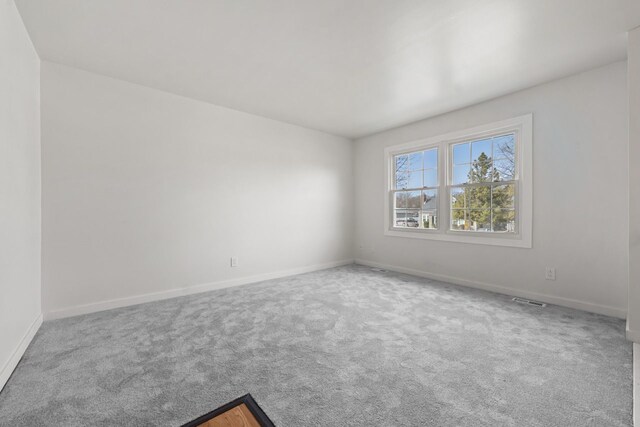 carpeted empty room with visible vents and baseboards