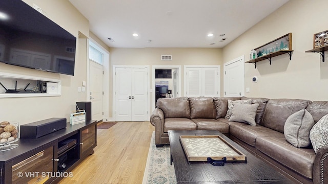 living room with recessed lighting, visible vents, and light wood-type flooring