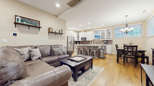 living area featuring recessed lighting, a notable chandelier, light wood-type flooring, and visible vents