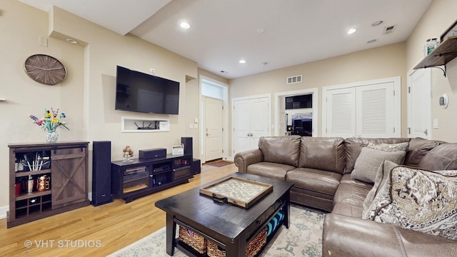 living room featuring recessed lighting, light wood finished floors, and visible vents